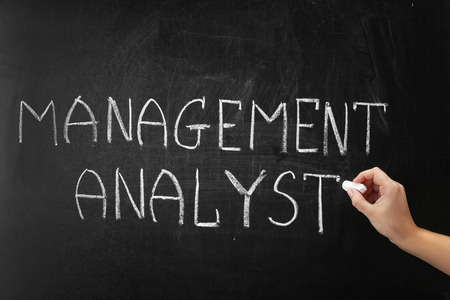Hand writing phrase MANAGEMENT ANALYST on blackboardの写真素材