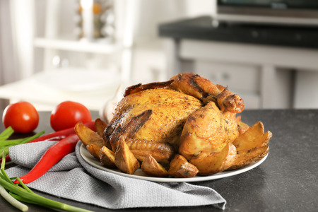 Plate with roasted beer can chicken on gray tableの写真素材