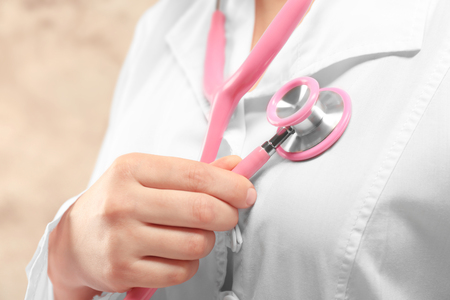 Female doctor hand holding stethoscope on chestの写真素材