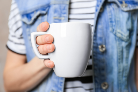 Blank white cup in hand, closeupの写真素材