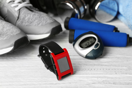 Heart rate monitor watch and sportive equipment on light wooden backgroundの写真素材