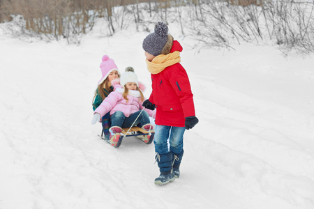 Happy children having fun and sledding on snowの写真素材