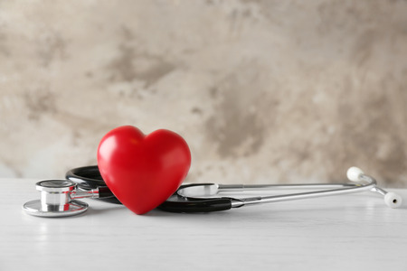 Stethoscope and red heart on tableの写真素材