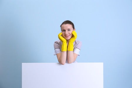 Beautiful chambermaid in uniform on color backgroundの写真素材