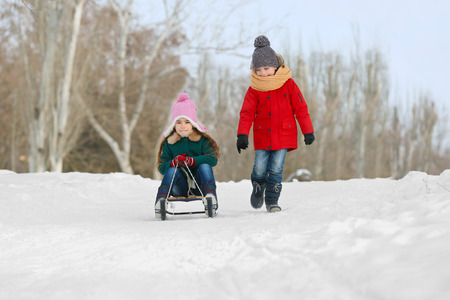 Happy children having fun and sledding on snowの写真素材