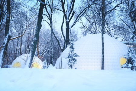 Illuminated tents in evening winter park