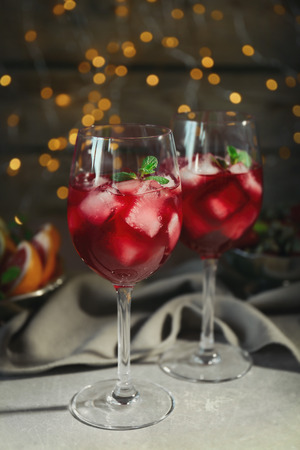 Glasses of delicious wine spritzer on blurred lights backgroundの写真素材