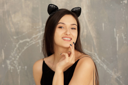 Beautiful young woman with cat ears on grunge backgroundの写真素材