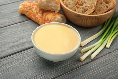 Bowl with beer cheese dip and bread on wooden backgroundの写真素材