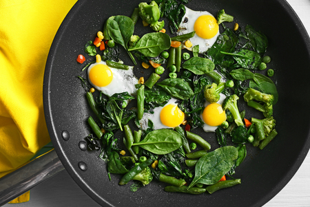 Delicious roasted quail eggs with spinach and french bean on pan, closeupの写真素材