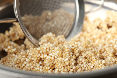 Quinoa seeds and sieve in saucepan, closeupの写真素材