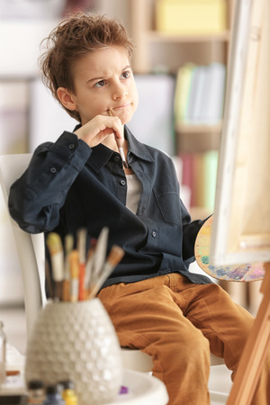 Cute little artist painting picture in studioの写真素材