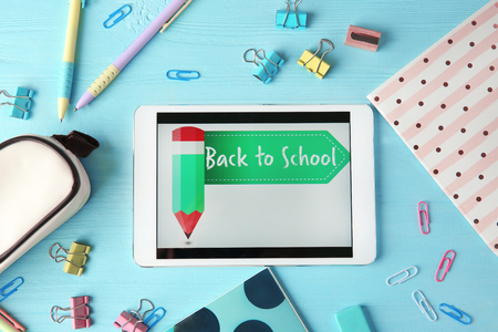 Tablet with BACK TO SCHOOL message and stationery on wooden backgroundの写真素材