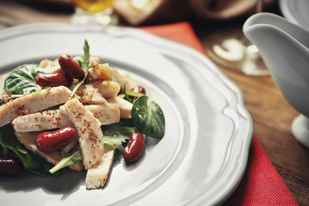 Tasty dish with chicken, beans, arugula and spinach on plateの写真素材