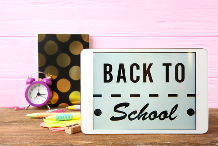 Tablet with BACK TO SCHOOL message and stationery on wooden tableの写真素材