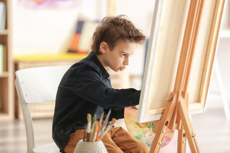 Cute little artist painting picture in studioの写真素材