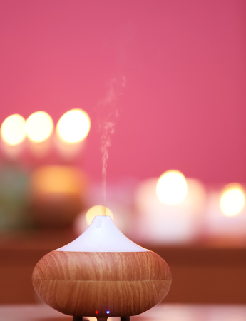 Aroma oil diffuser on blurred candlelight backgroundの写真素材