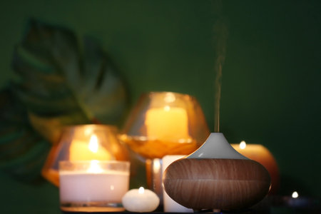 Aroma oil diffuser on blurred candles backgroundの写真素材