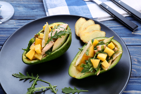 Plate with chicken salad in boats from avocado on tableの写真素材