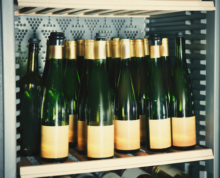 Wine bottles cooling in refrigeratorの写真素材