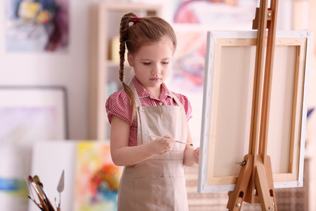 Cute little artist painting picture in studioの写真素材