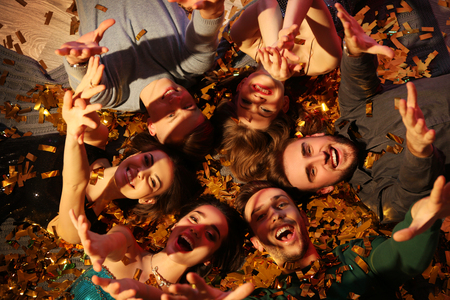 Friends lying on floor at party in night club