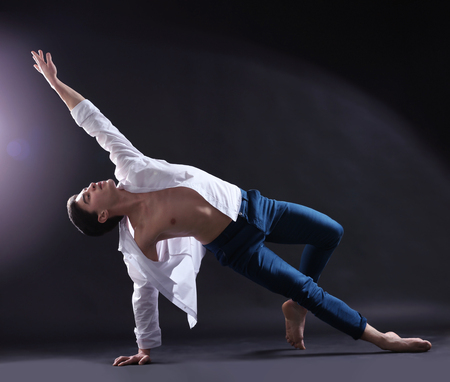 Handsome young ballet dancer on dark background