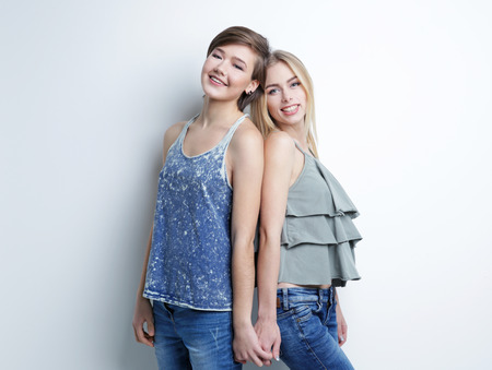 Young lesbian couple on light backgroundの写真素材