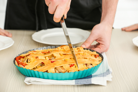 Male hand cutting tasty pie, closeupの写真素材