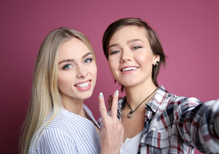 Young lesbian couple on color backgroundの写真素材