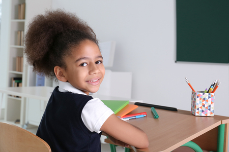 Portrait of cute African-American girl in classroomの写真素材