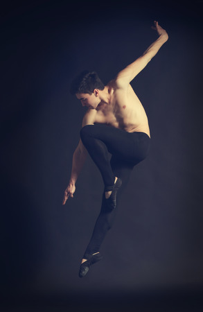 Handsome young ballet dancer on dark backgroundの写真素材