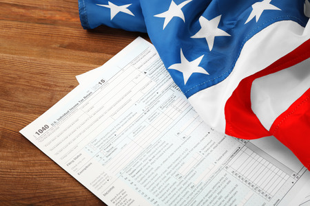Individual tax return form and American flag on wooden tableの写真素材