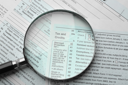 Income tax return form with magnifying glassの写真素材