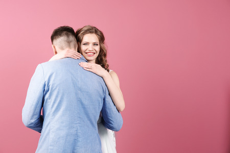Happy wedding couple on color backgroundの写真素材
