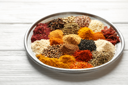 Tray with mix of different spices on wooden tableの写真素材