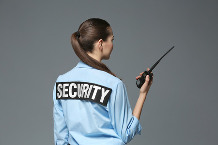 Beautiful security guard on grey backgroundの写真素材