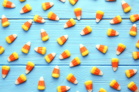 Colorful Halloween candy corns on wooden background