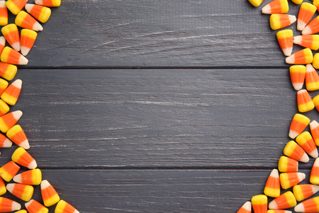 Colorful Halloween candy corns on wooden background