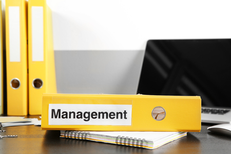 Folder with label MANAGEMENT on wooden tableの写真素材