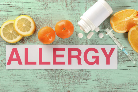 Word ALLERGY, food and pills on wooden backgroundの写真素材