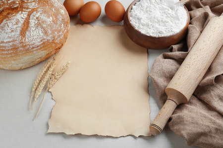 Sheet of paper with space for text and bread on light backgroundの写真素材