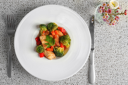 Plate of chicken stir fry with vegetables on tableの写真素材