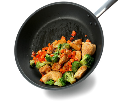 Chicken stir fry with vegetables in pan on white backgroundの写真素材