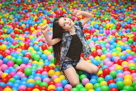 Cute girl playing with plastic balls