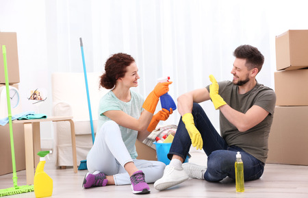 Happy young couple cleaning home togetherの写真素材