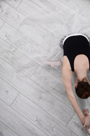 Ballet art concept. Young ballerina stretching on floorの写真素材
