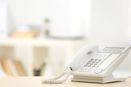 Telephone on wooden table in officeの写真素材