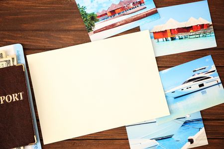 Travel concept. Blank notepad page with space for text and passport on wooden backgroundの写真素材