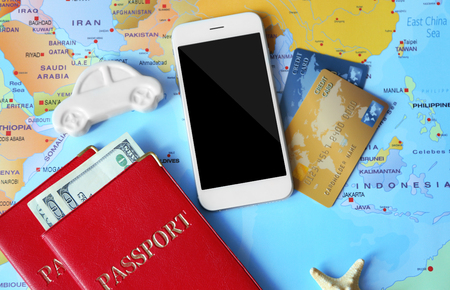 Smartphone, passports and credit cards on world map backgroundの写真素材